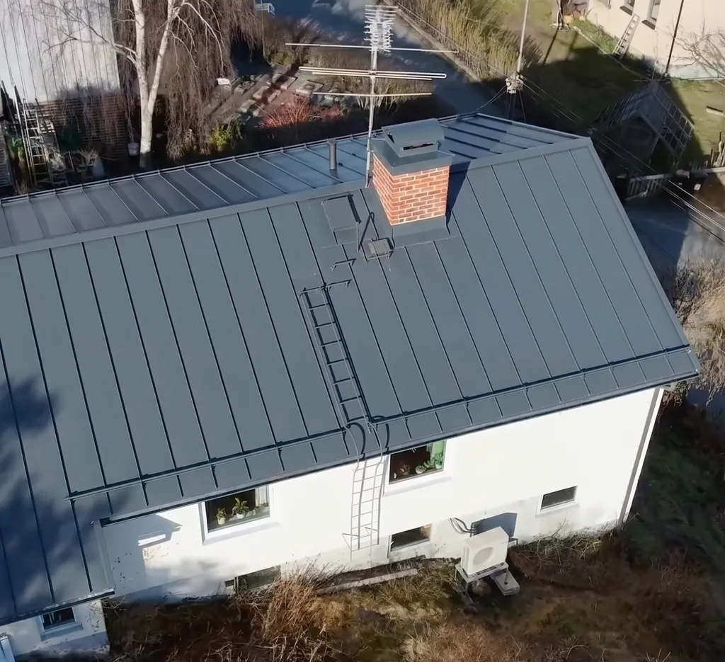 Professionell taktvättare med lågtrycksspruta på nytvättat tegeltak