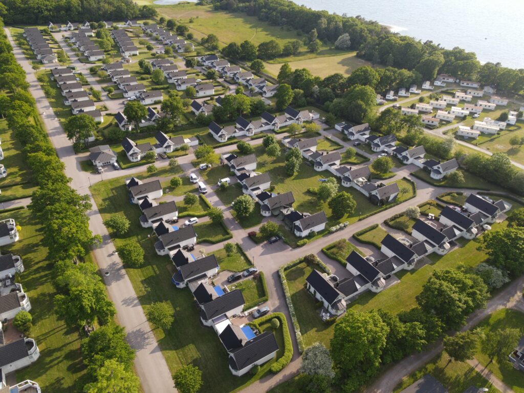 Drönarvy över villaområde med rena tak i kvällsljus